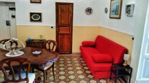 salon z czerwoną kanapą i stołem w obiekcie CERASELLA -vista mare- w mieście Vietri sul Mare