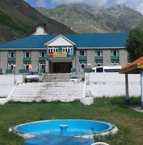 a building with a blue pool in front of a building at Troutland Hotel Naran in Naran