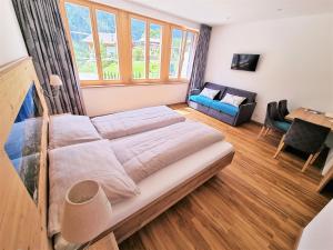 1 dormitorio con 1 cama grande y 1 sofá en Triftblick en Gadmen