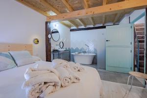1 dormitorio con 1 cama con toallas en VEN LUNA, VEN Casa-SPA Astroturismo rural TR-CC-00361 en Casas del Castañar