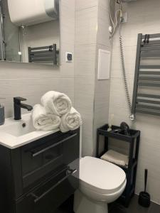 a bathroom with a toilet and a sink with towels at SEN na CICHEJ - Apartamenty w PARKU in Polanica-Zdrój
