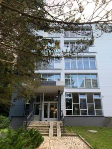 un edificio blanco con escaleras delante en SEN na CICHEJ - Apartamenty w PARKU, en Polanica-Zdrój