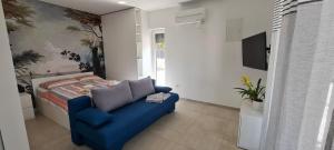 a bedroom with a blue couch and a bed at CUBE apartments in Vir