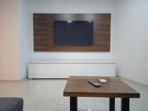 a living room with a table and a tv on a wall at Anton in Povlja