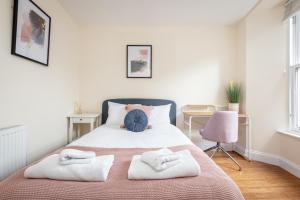 1 dormitorio con 1 cama con 2 toallas en Skye Sands - Central Apartment near The Old Course en St Andrews