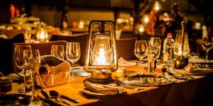 - une table avec des verres à vin et une lanterne dans l'établissement Ku Sungula Safari Lodge, à Réserve de Balule