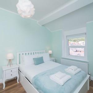 Un dormitorio blanco con una cama blanca y una ventana en Great Orme Apartment by Seaside Llandudno, en Llandudno