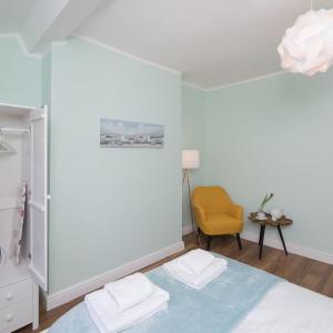 1 dormitorio con 1 cama y 1 silla amarilla en Great Orme Apartment by Seaside Llandudno, en Llandudno