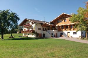 ein großes Haus mit grünem Rasen davor in der Unterkunft Kachlerhof in Kastelruth