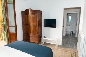 um quarto com uma cama, uma cómoda e uma televisão em La Candida Rosa em Florença