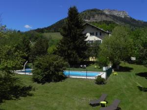 een huis met een zwembad in een tuin bij Hôtel des Skieurs in Le Sappey-en-Chartreuse