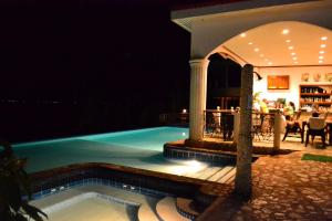 a swimming pool at night with a bar in the background at Eden Resort in Santander