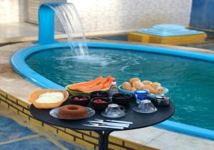 a tray of food sitting next to a swimming pool at Joia do Paraiso - Macapá Luís Correia in Luis Correia