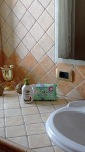 a bathroom counter with a sink and a bottle of soap at Appartamento U scrusciu ro mari in Marzamemi