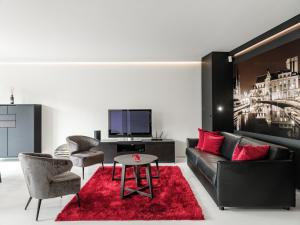 Lord of Ghent في خنت: غرفة معيشة مع أريكة سوداء وسجادة حمراء