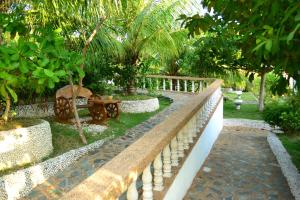 a stone wall with a bench in a garden at Eden Resort in Santander