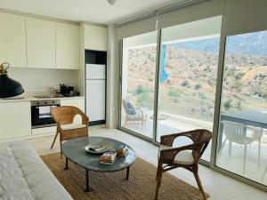 a kitchen and living room with a table and chairs at Caldera Blue in Alikí