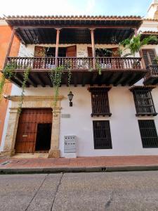 Edificio blanco con balcón y puerta en Hotel Boutique Casa Córdoba Estrella, en Cartagena de Indias