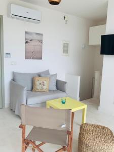 a living room with a couch and a yellow table at Caldera Blue in Alikí