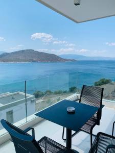 a blue table and chairs on a balcony with the ocean at Caldera Blue in Alikí