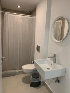 a bathroom with a sink and a toilet and a mirror at Caldera Blue in Alikí +99 photos