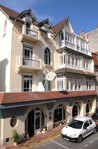 een witte auto geparkeerd voor een gebouw bij AUBERGE RIVA BELLA in Le Touquet-Paris-Plage