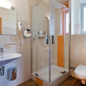 a bathroom with a shower and a sink at Sonn'Idyll Hotel & Saunalandschaft in Rathenow