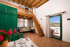 a living room with a green door and a staircase at Arhitektoniki Studios in Astypalaia