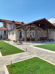 un patio con padiglione con panchine e prato di VILA GE a Sebeş