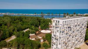 an aerial view of a tall white building next to the water at Sea view Oxygen Neptun in Neptun