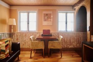 a dining room with a table and two windows at Casa da Praça Velha Guest House in Braga +27 photos