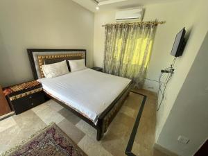 a bedroom with a bed and a television in it at Star light in Islamabad +2 photos