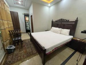 a bedroom with a bed and a chair in it at Star light in Islamabad