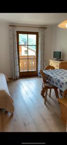 1 dormitorio con cama, mesa y ventana en Appartament Anna 4, en Predoi