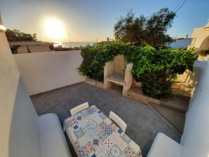 einen Tisch und Stühle auf einer Terrasse mit Meerblick im Hintergrund in der Unterkunft MONOLOCALE LA GROTTA in Capilungo