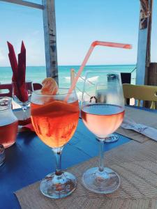 two glasses of wine sitting on a table near the ocean at Sea view Oxygen Neptun in Neptun +12 photos