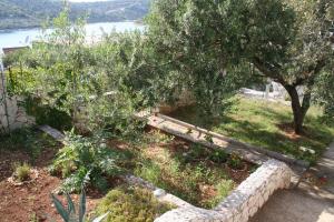 a garden with trees and a stone wall at Apartment Sevid in Sevid