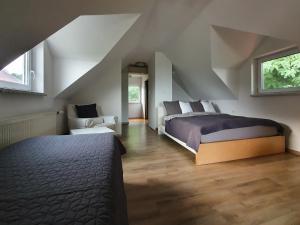 a bedroom with a bed and a chair in a attic at Počitniška hiša Grube z wellnesom in Puconci