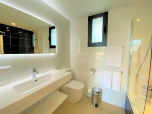 a white bathroom with a sink and a toilet at Villa LUCIA in Cala en Blanes +3 photos