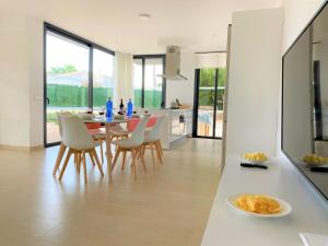 una cucina e una sala da pranzo con tavolo e sedie di Villa LUCIA a Cala en Blanes