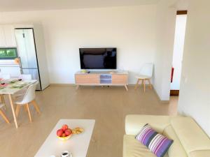 un soggiorno con divano e TV di Villa LUCIA a Cala en Blanes