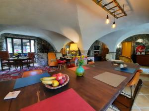 a dining room with a table with a bowl of fruit on it at La Bergerie à Menée in Châtillon-en-Diois