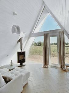 a living room with a white couch and a window at Woody Village Riverside in Panteleyevo