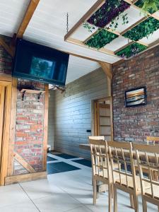 a living room with a tv and a brick wall at VERTIKĀLES in Liepāja