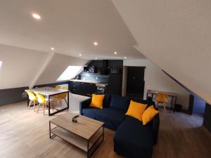 un soggiorno con divano blu e tavolo di Appartement 5 Cherbourg centre avec NETFLIX et WIFI a Cherbourg en Cotentin