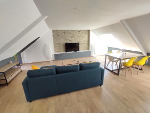 a living room with a blue couch and a table at Appartement 5 Cherbourg centre avec NETFLIX et WIFI in Cherbourg en Cotentin