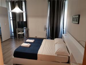 a bedroom with a bed with two towels on it at B&B Porto Vecchio ROOMS - Stazione Centrale Trieste in Trieste