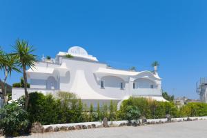 a white house with a palm tree in front of it at Ischia Mavilan Luxury Apartments in Ischia