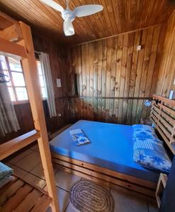 ein Schlafzimmer mit einem blauen Bett in einer Holzhütte in der Unterkunft Cantinho do paraíso in Gamboa