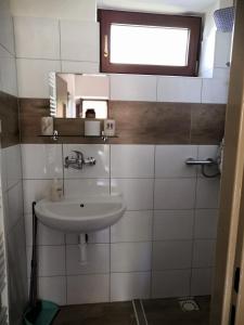 een badkamer met een wastafel en een spiegel bij Apartmán Rózsika in Veľký Meder